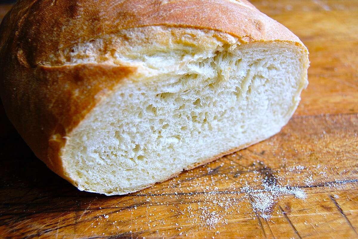 Loaf of sourdough bread on a cutting board, sliced.